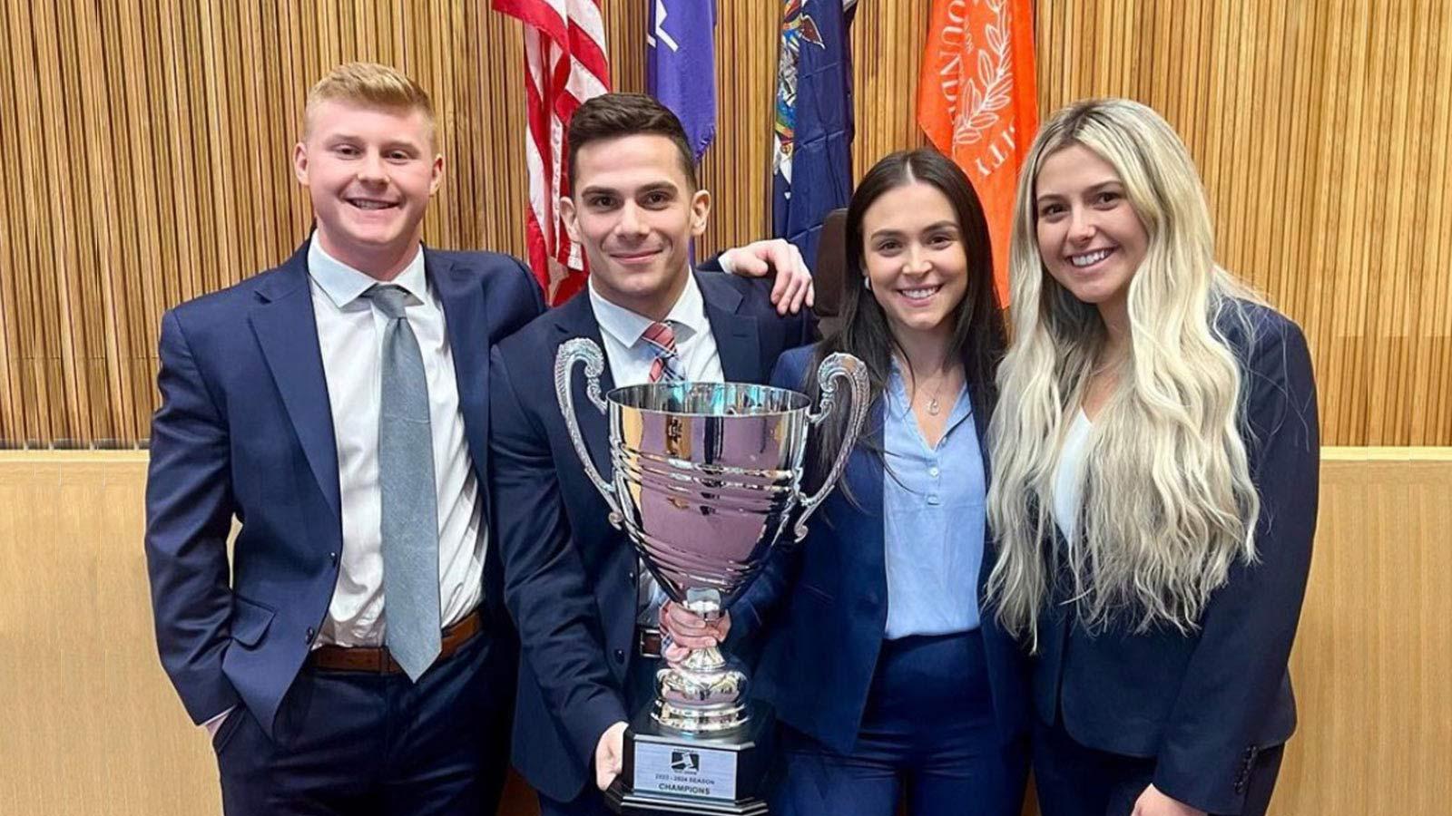 Elisabeth Haub School of Law’s trial team posing with the championship trophy