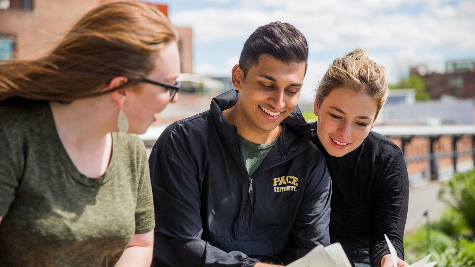 group of Pace students sitting on the lawn and benches on the Pleasantville Campus