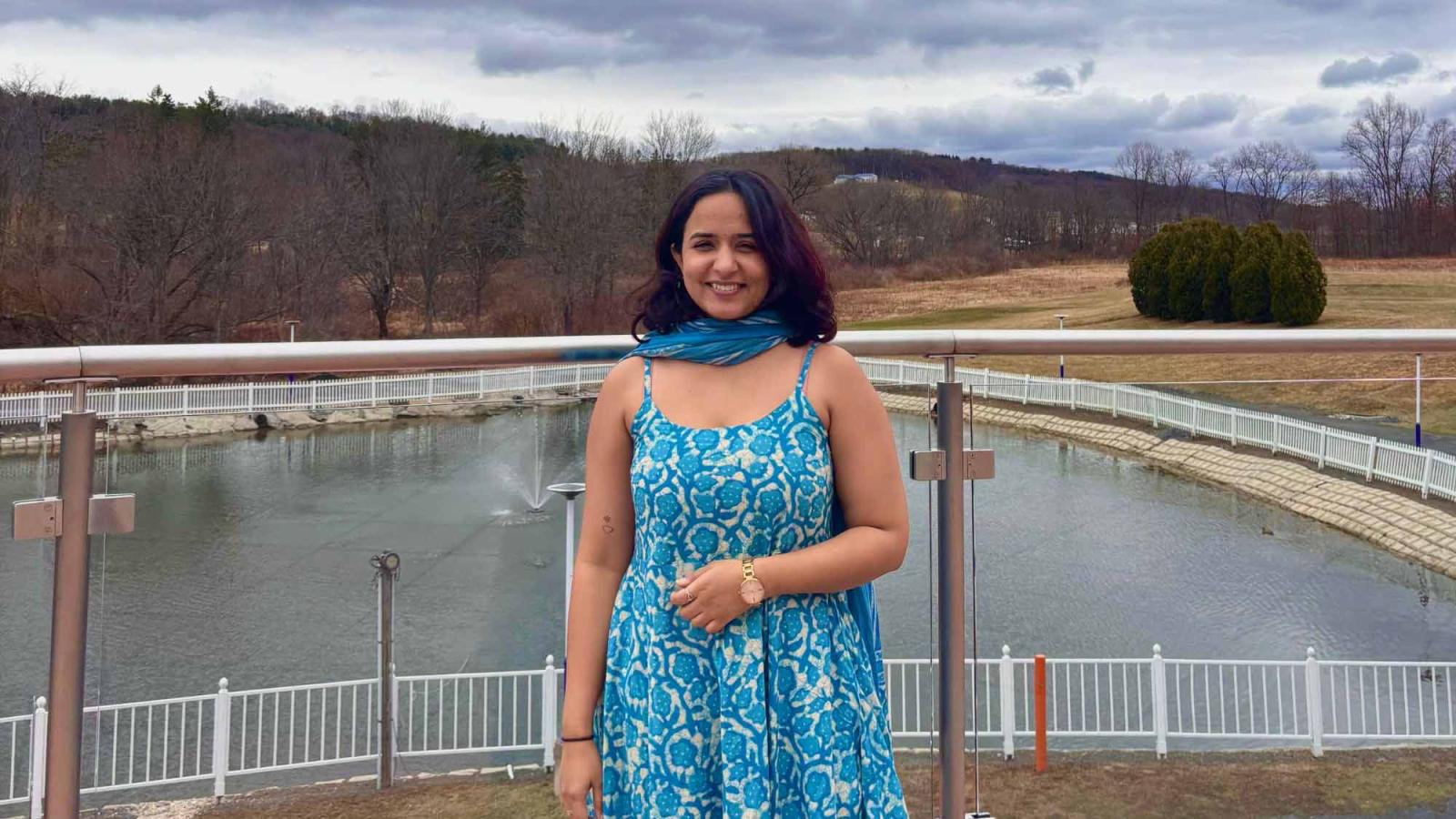 Seidenberg student Riya Golani smiling for a photo in front of a lake in nature.