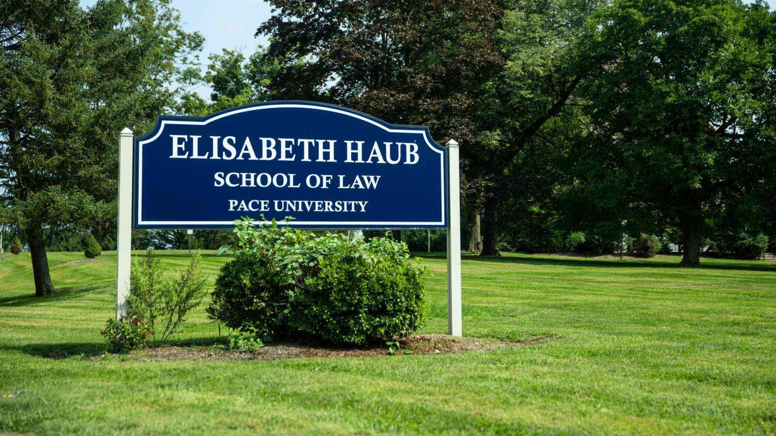 A sign on a green lawn reading Elisabeth Haub School of Law Pace University.