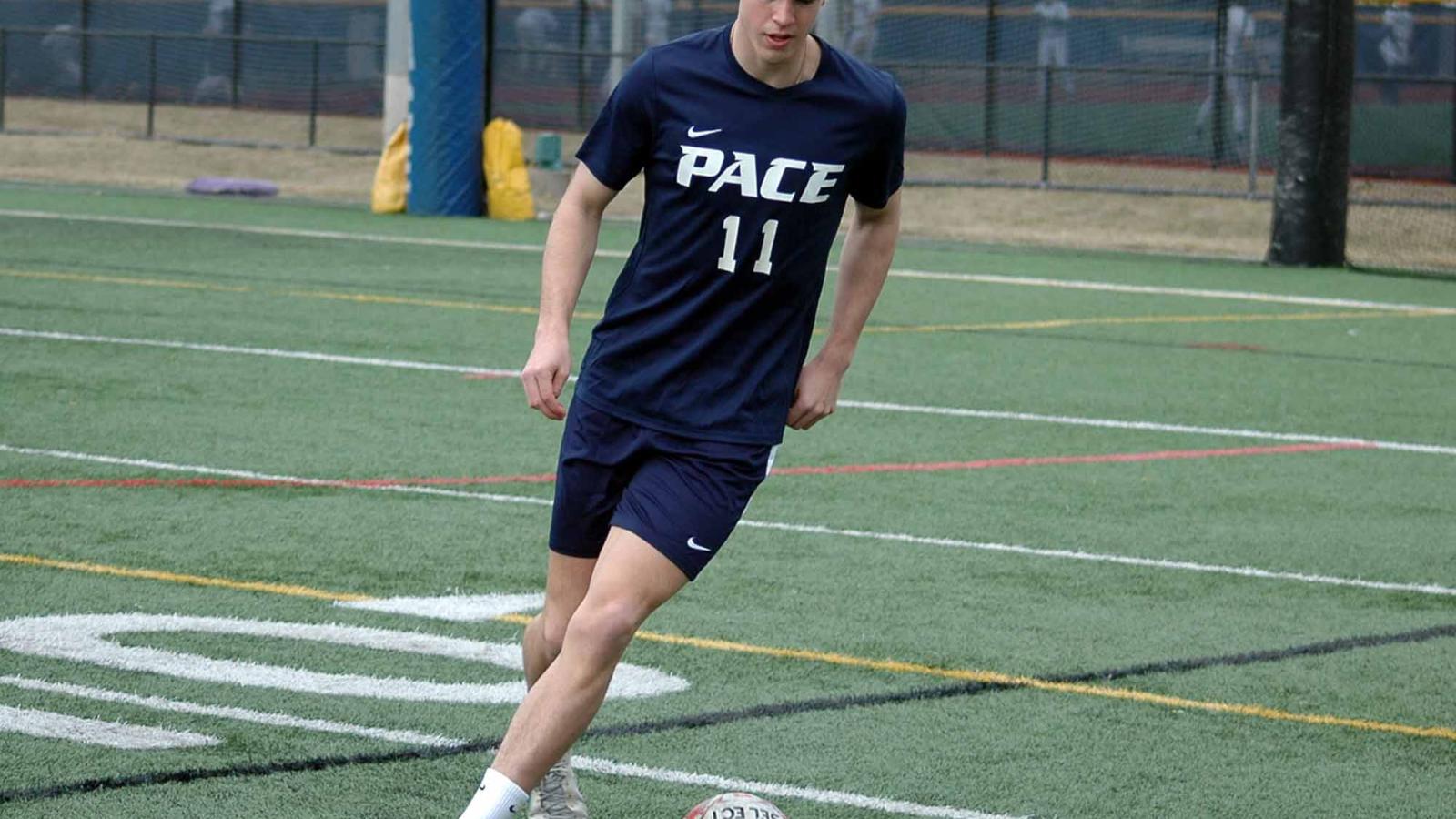 A Pace student kicking a soccer ball.