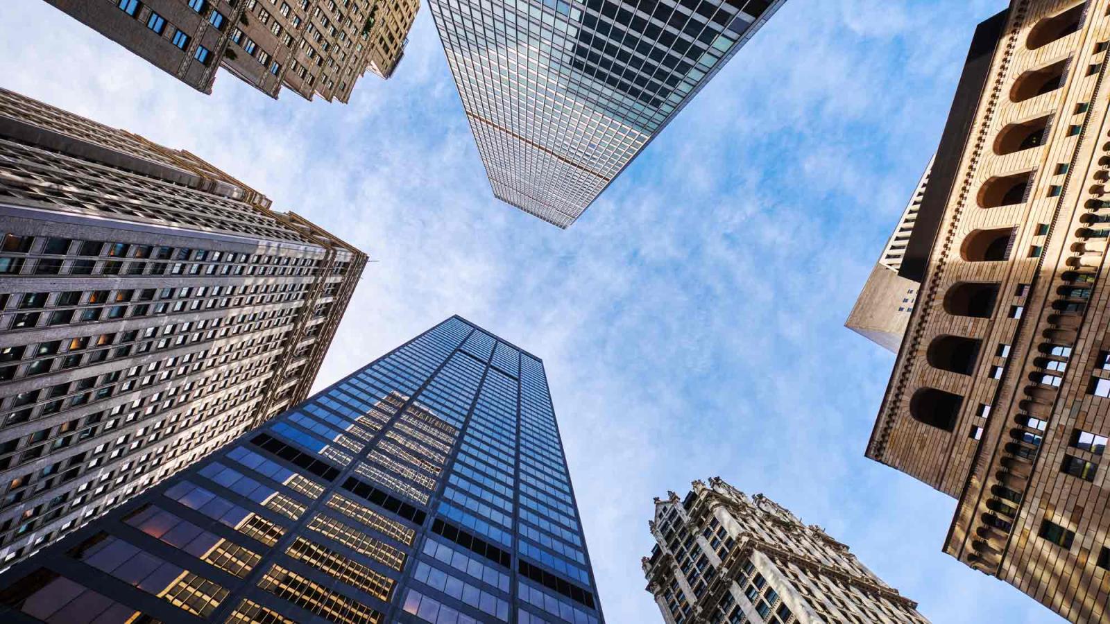 Skyscrapers against a blue sky viewed from street level.