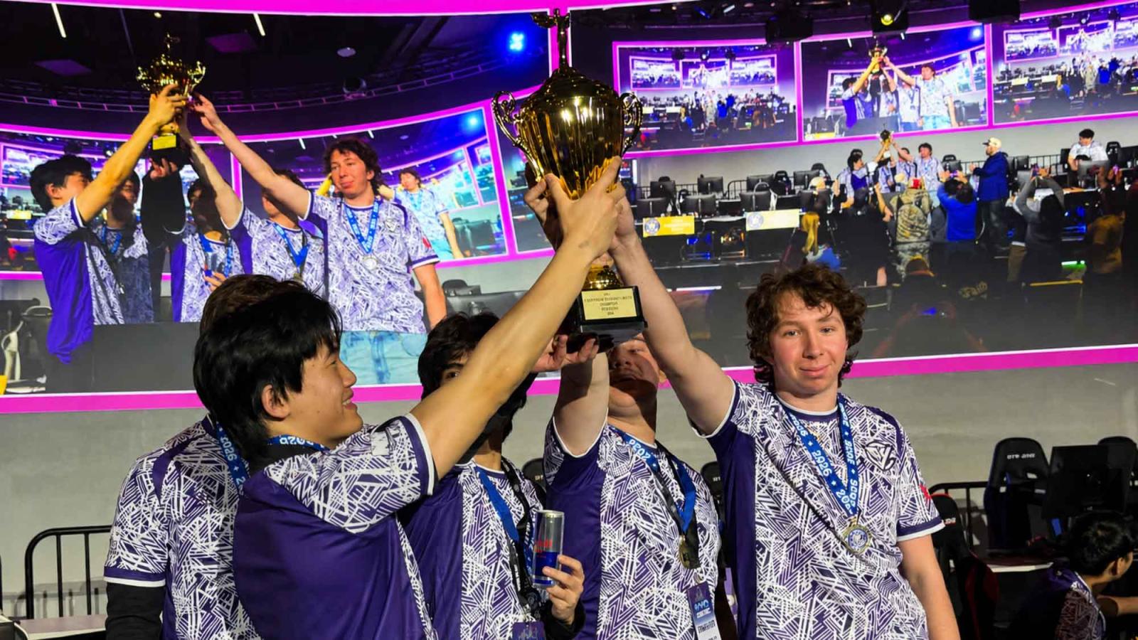 Pace University Esports athletes lift a trophy