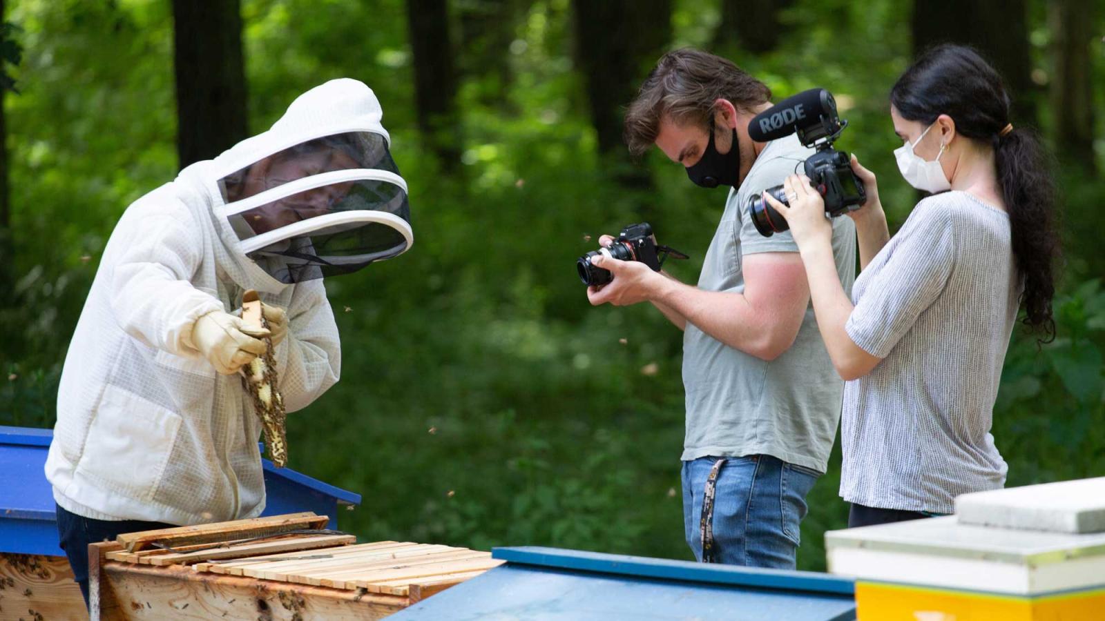 students filming a bee keeper