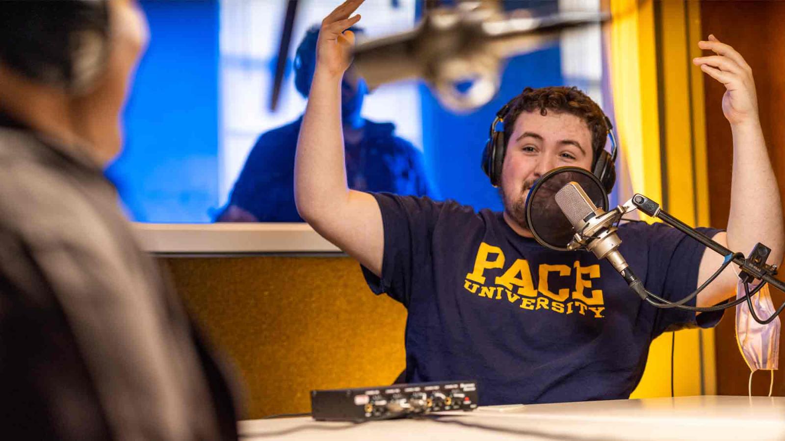 Dyson students in a recording studio on campus talking into microphones.