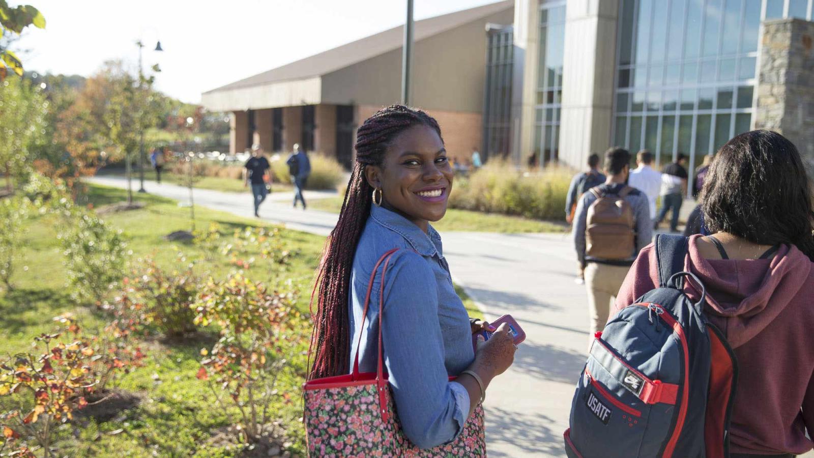female student walking toward buildings on Pace University's Pleasantville Campus