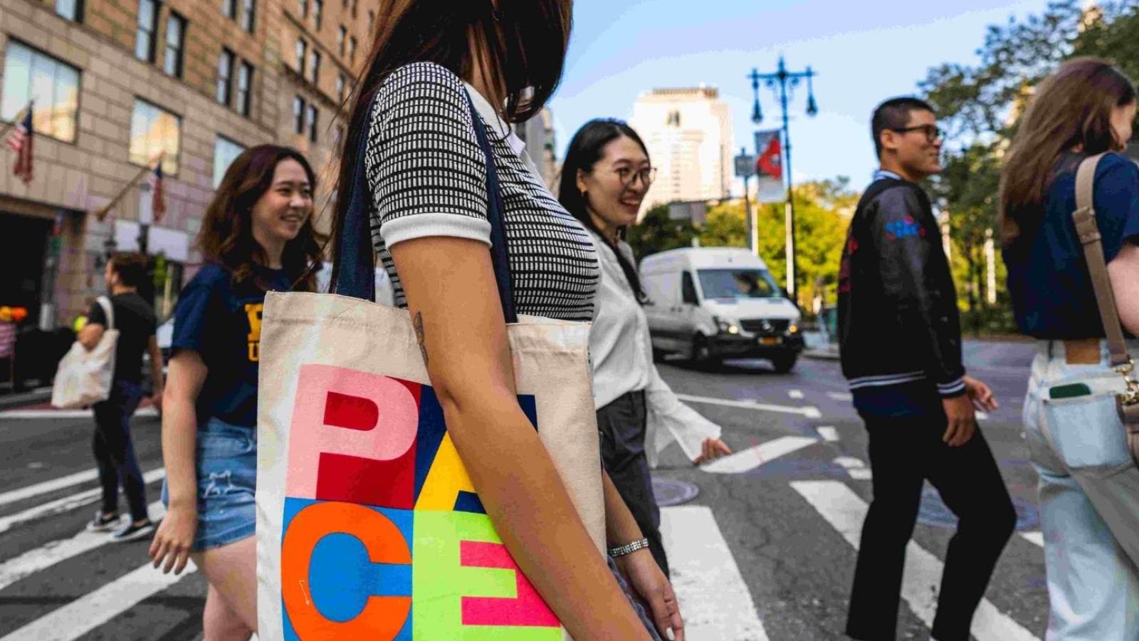 Pace University students crossing an NYC street wearing Pace apparel