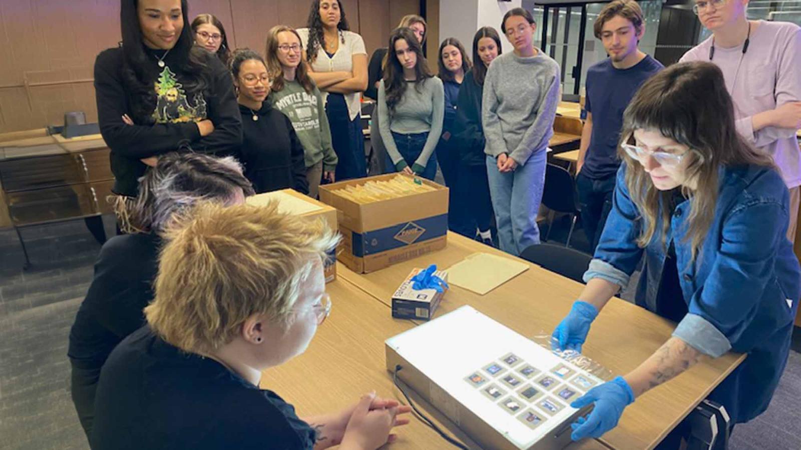 Pace University History professor Michelle Chase viewing slides with students on a light board