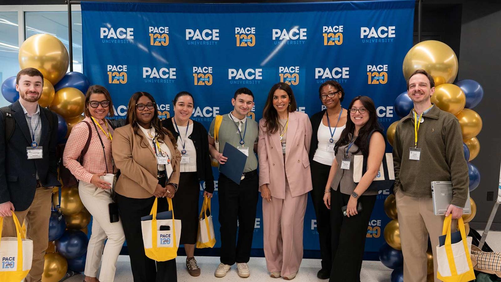 Group of Pace University employees smiling at the camera.