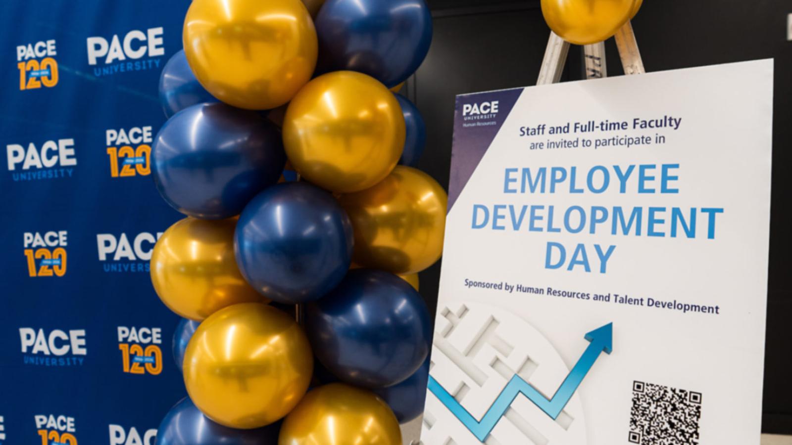 Blue and gold balloons next to a sign that reads Employee Development Day