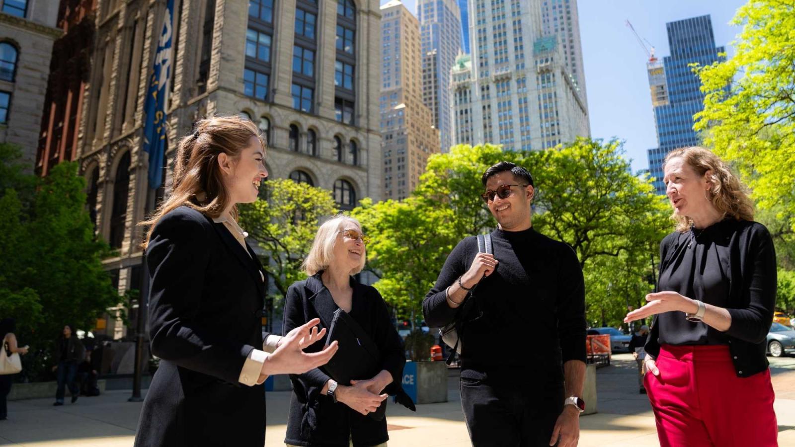 Faculty and students conversing on campus