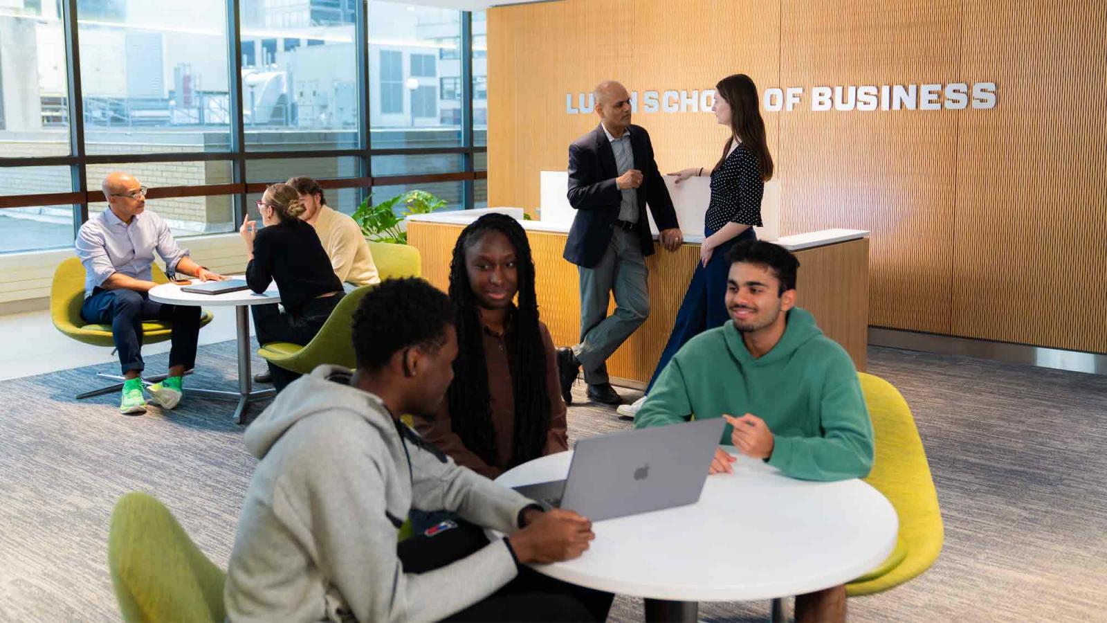 A group of students and staff in the Lubin School of Business lounge.
