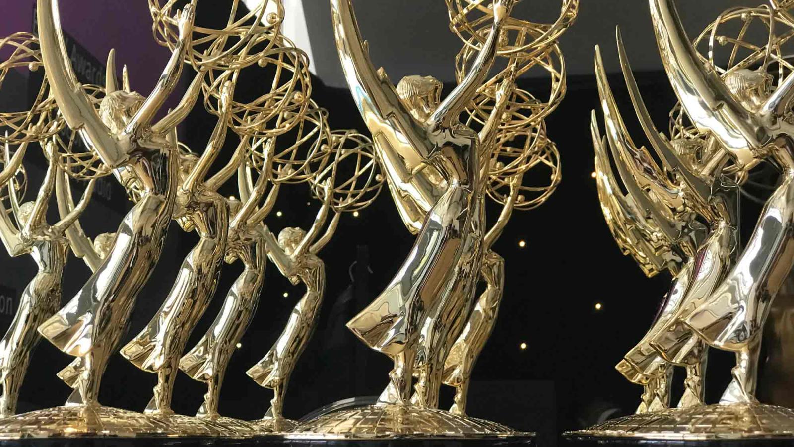 Many Emmy Awards on a table.