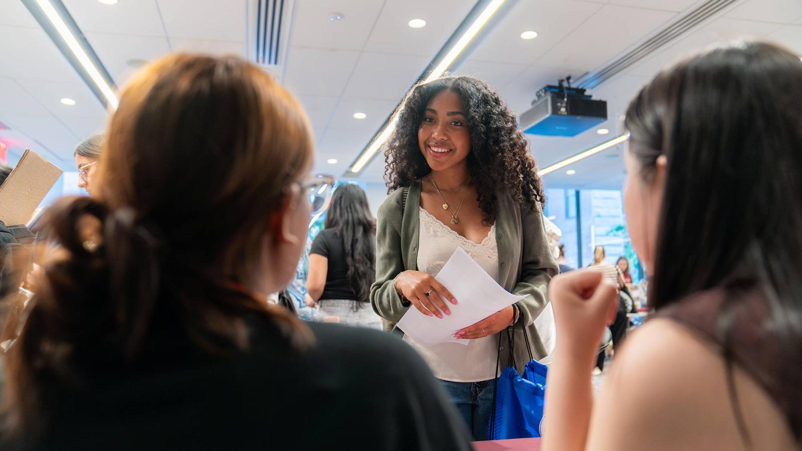Pace University student speaking with club representatives at the Student Engagement Fair
