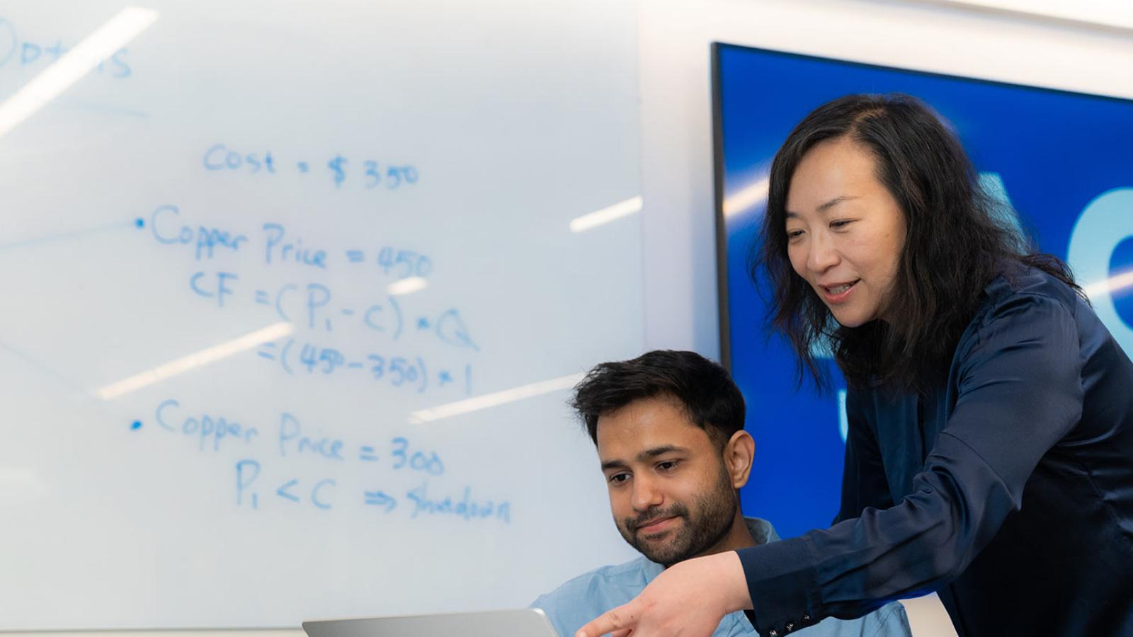 Finance and Economics department Professor Mingming Zhou talking to student