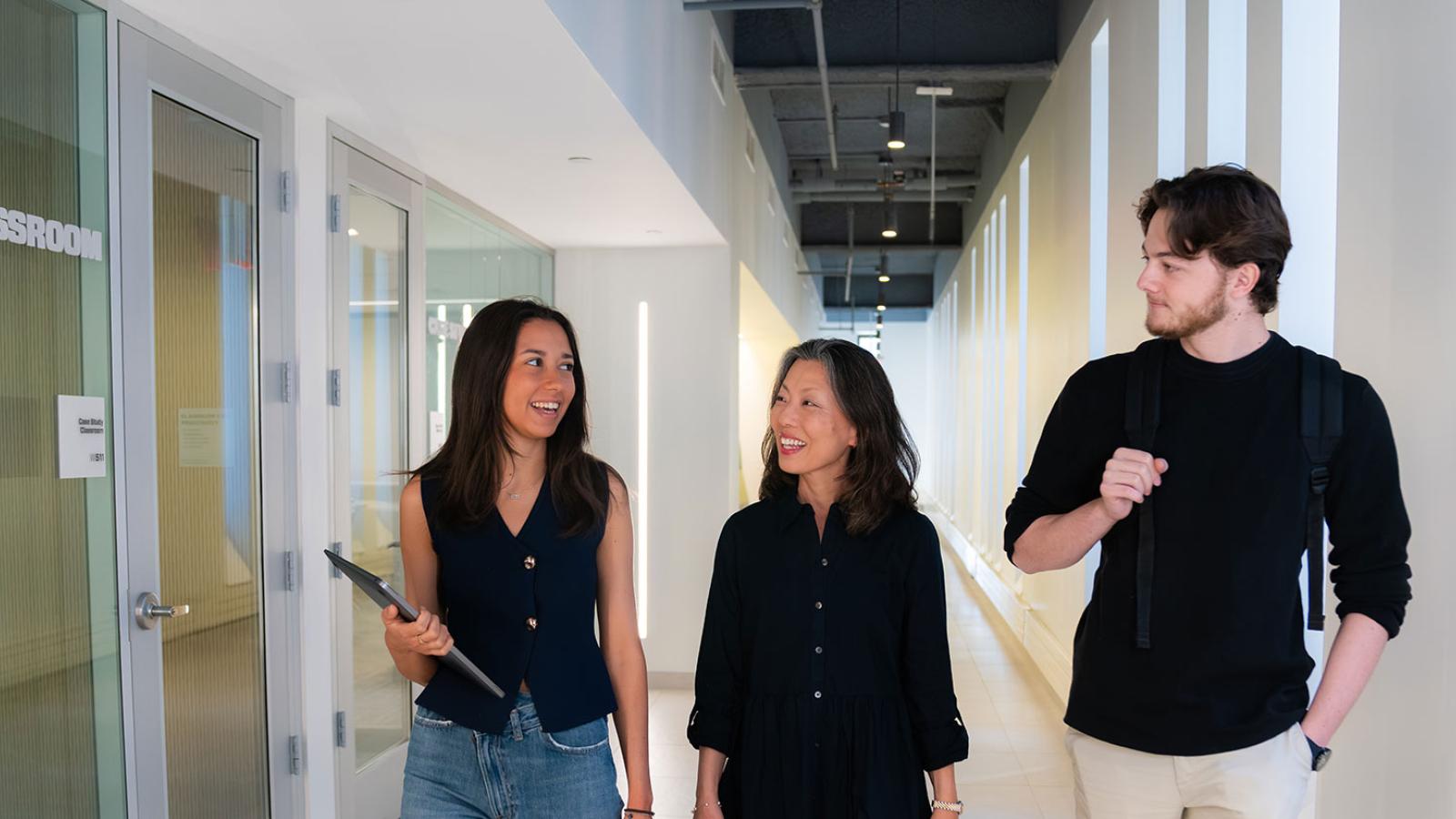 Three Pace University Lubin School of Business students and faculty walking together, talking