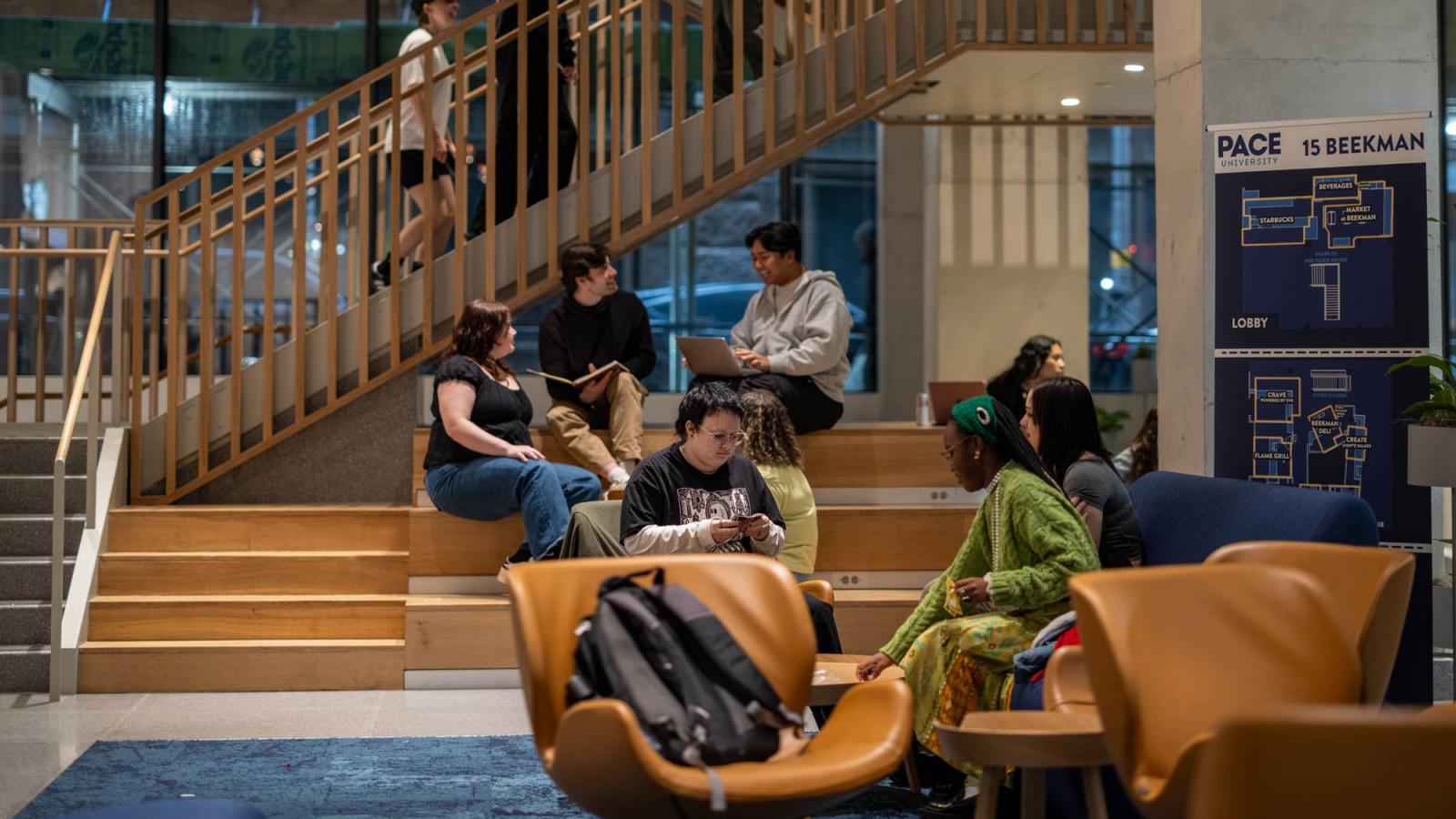 Group of Pace University students sitting in the lobby at 15 Beekman in NYC.