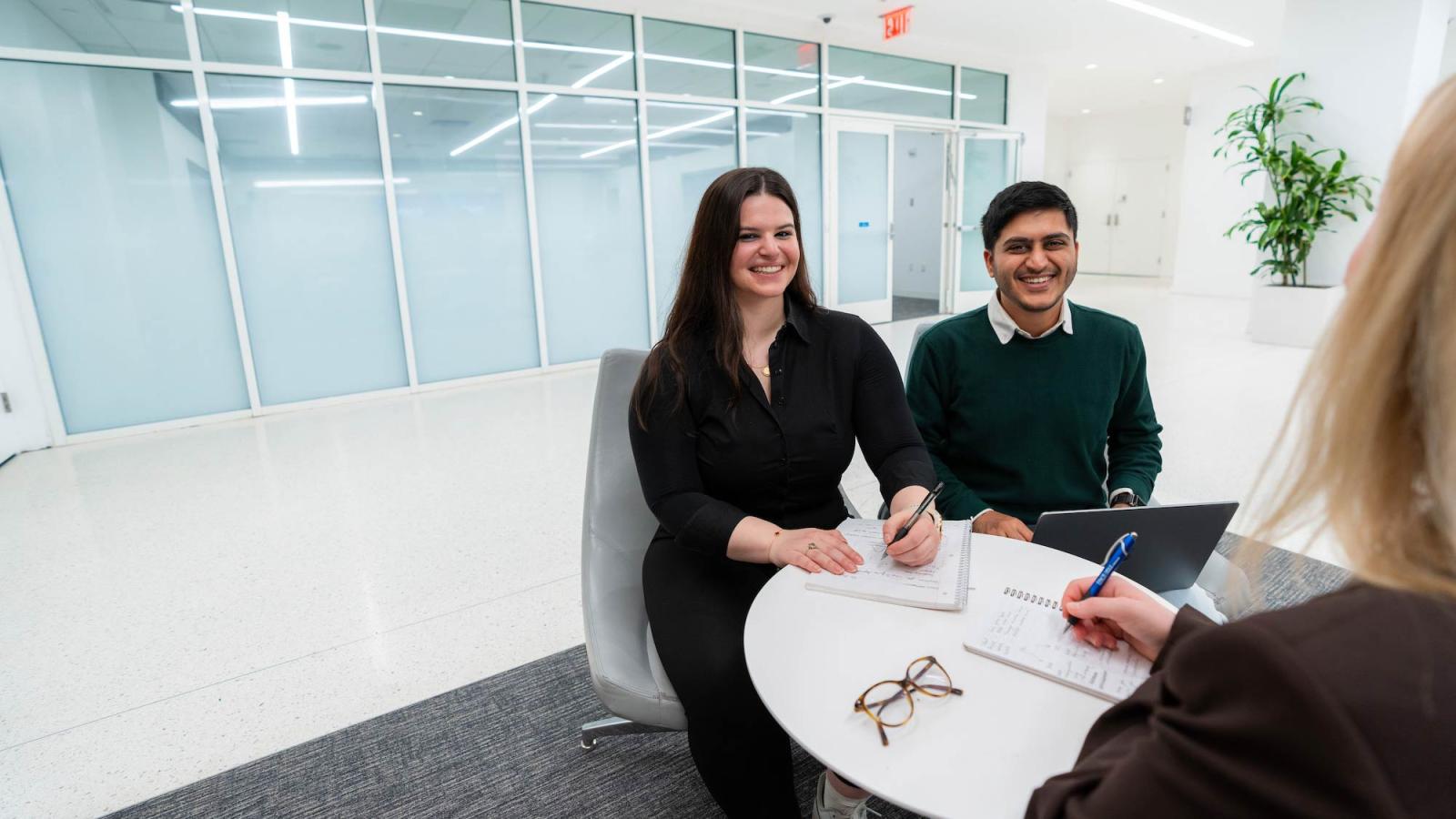 Two Pace University students meeting with an admissions counselor.