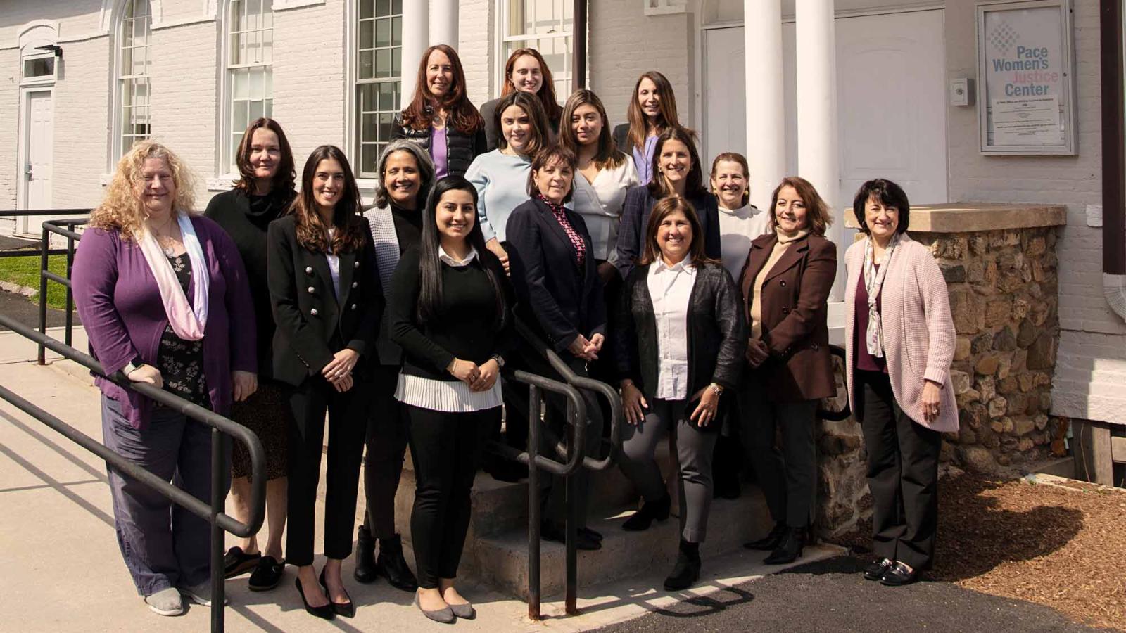 The staff of the Pace Women's Justice Center posing for a group photo in front of their building.