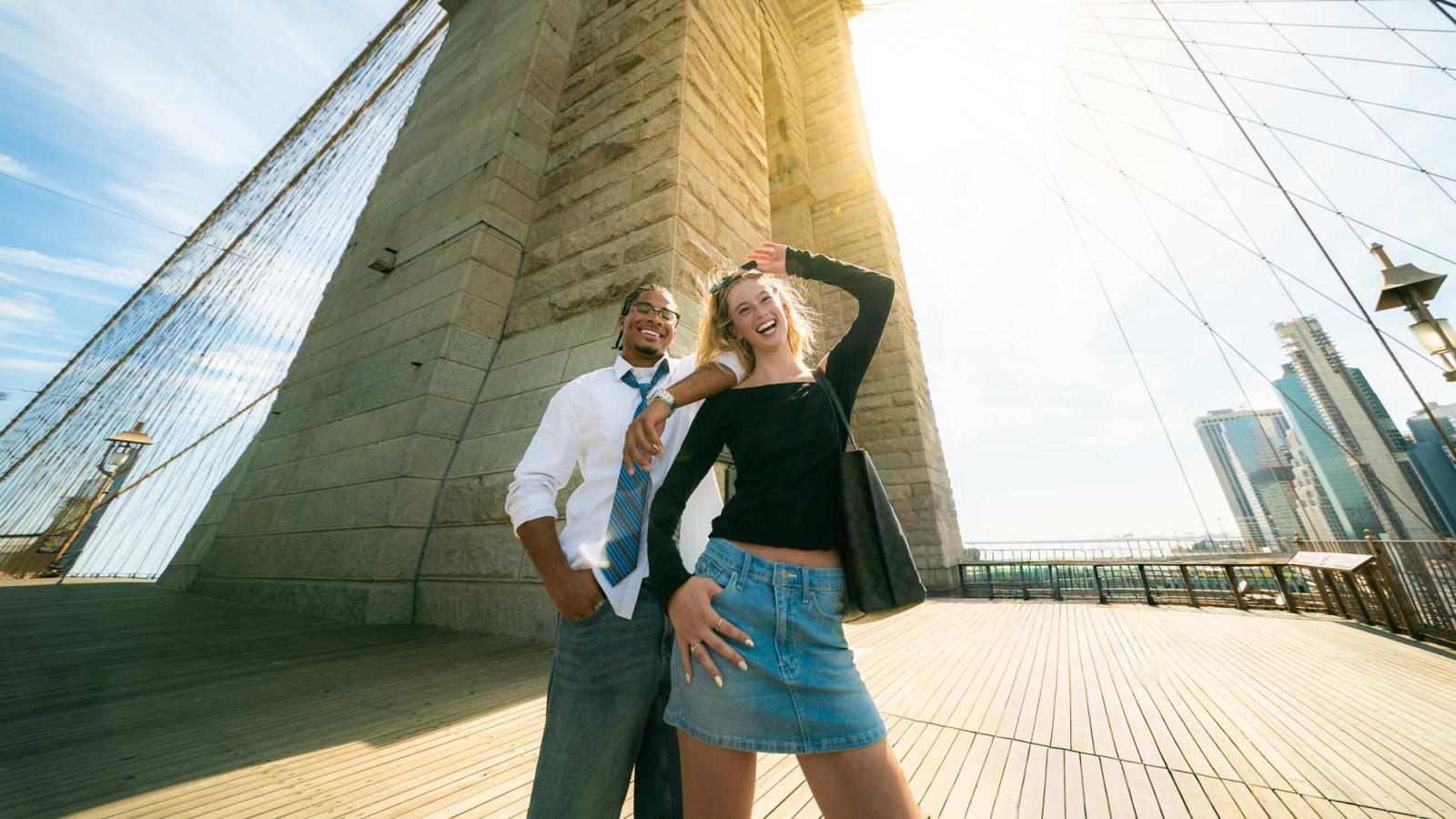 Two Pace University student at the Brooklyn Bridge in NYC, smiling at the camera.