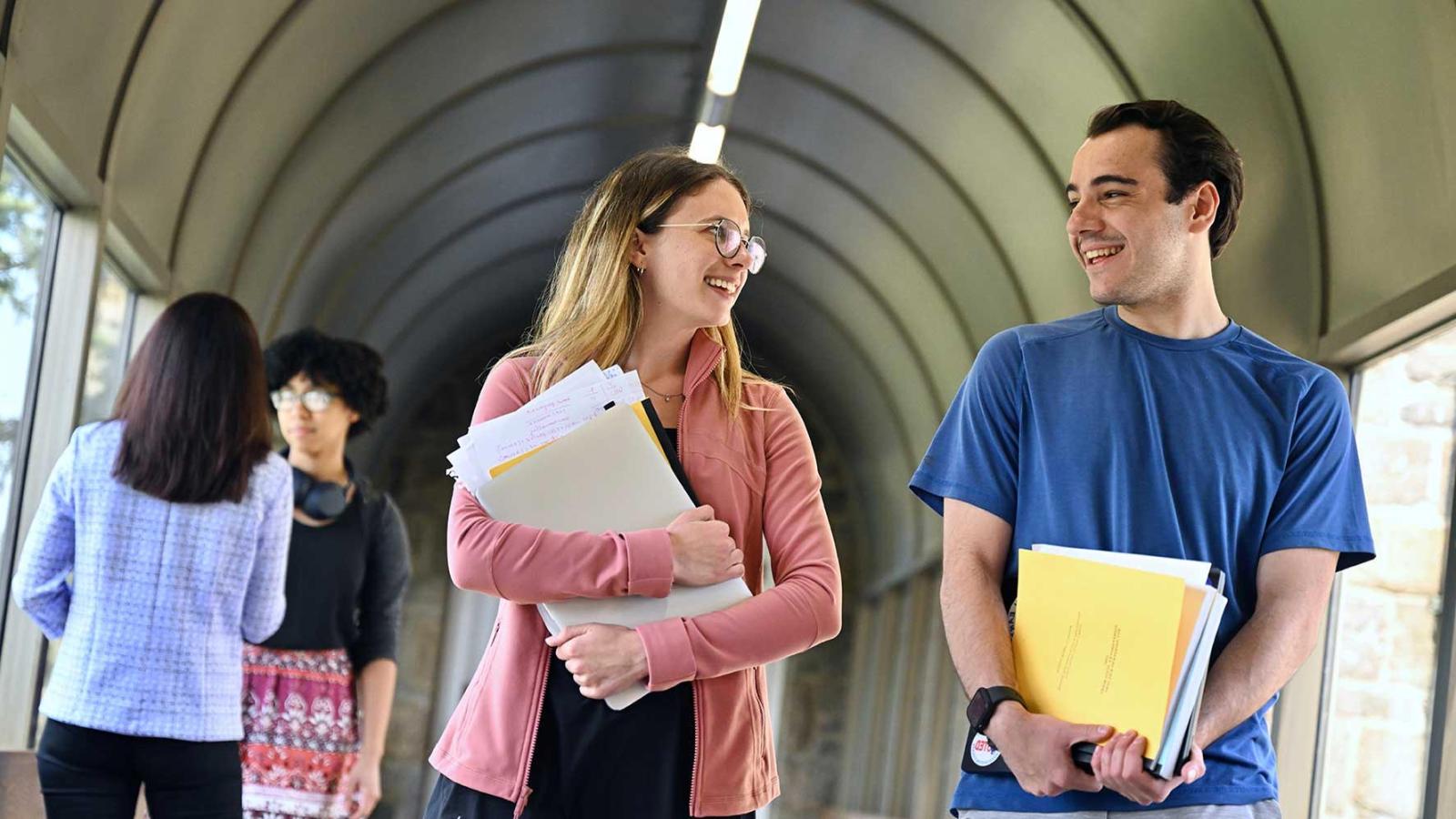 two students conversing in a hallway