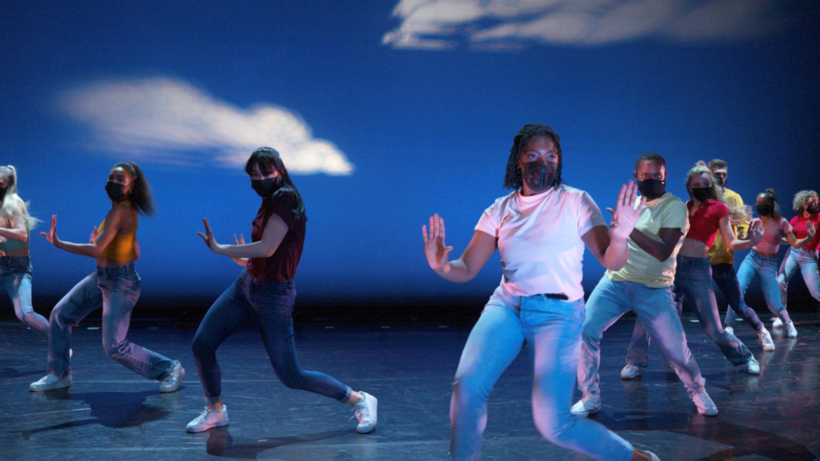 people dancing on stage in masks