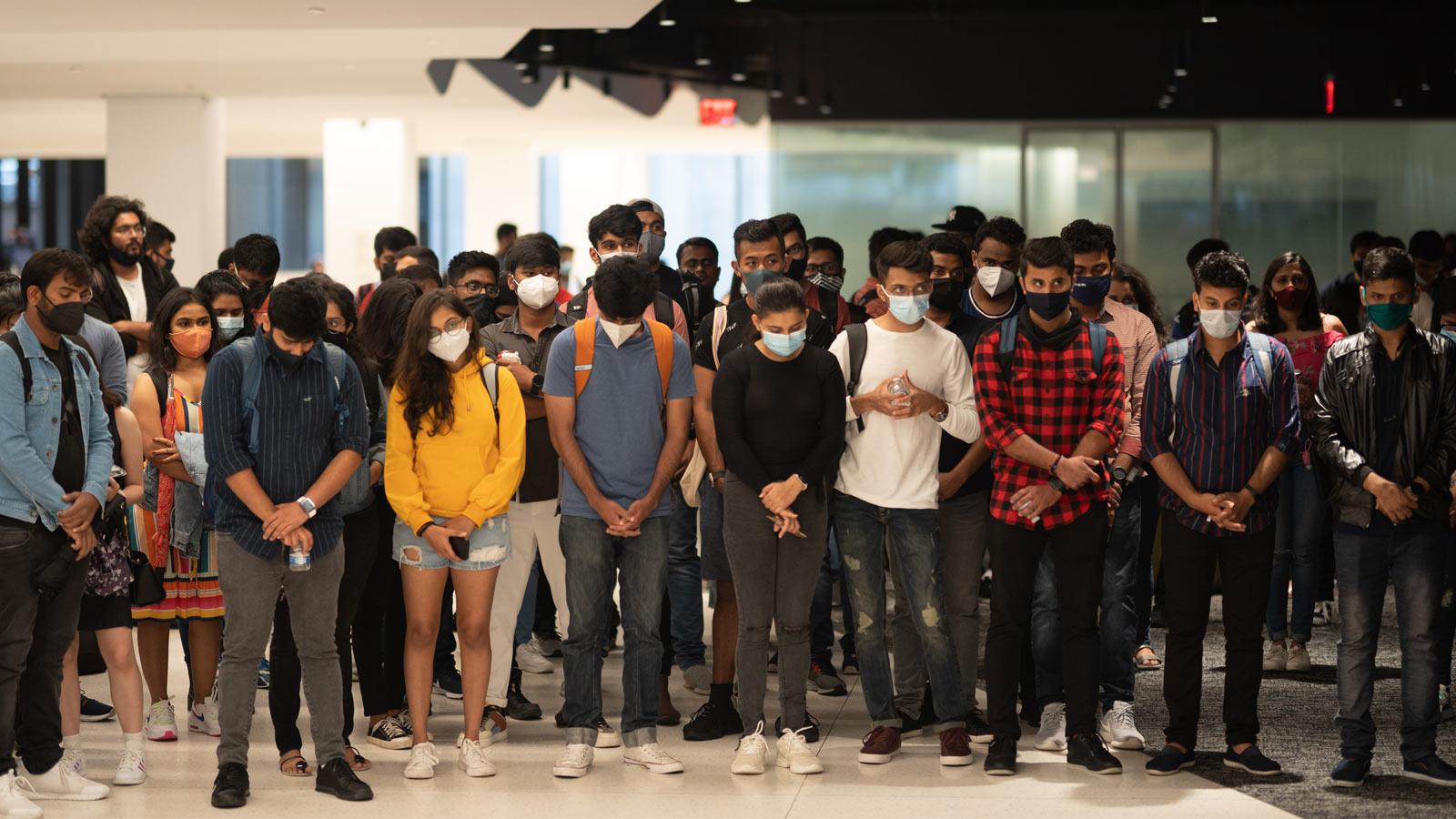 group of students with heads bowed