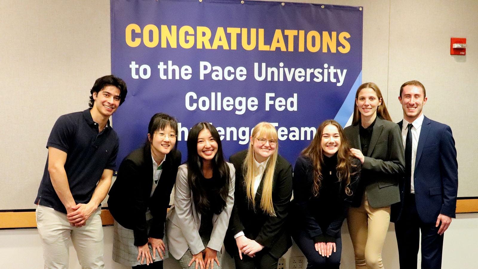 Federal Reserve Challenge 2022 Team in front of the Congratulations banner