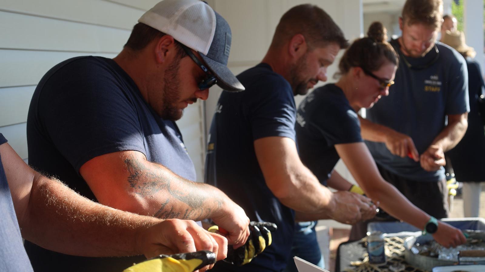 people shucking oysters