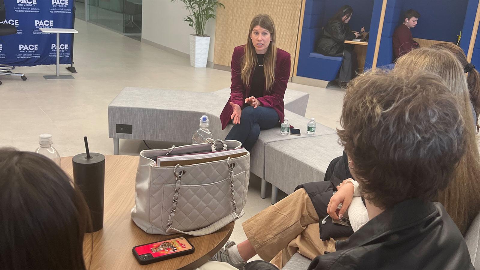 female guest speaker talking to students in the Lubin Central Corridor on the New York City Campus