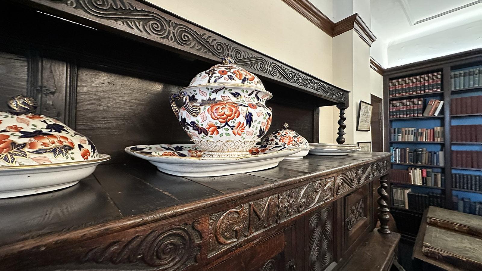 close up of antique floral china on a large wooden cupboard in the Pace Study.