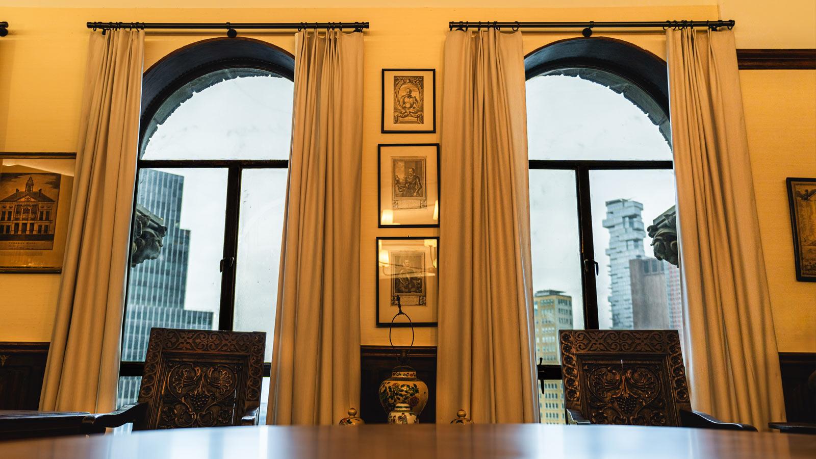 arched windows with curtains overlooking down town manhattan