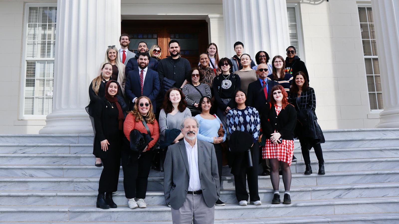 group posing on the steps of the Alabama State Capitol.