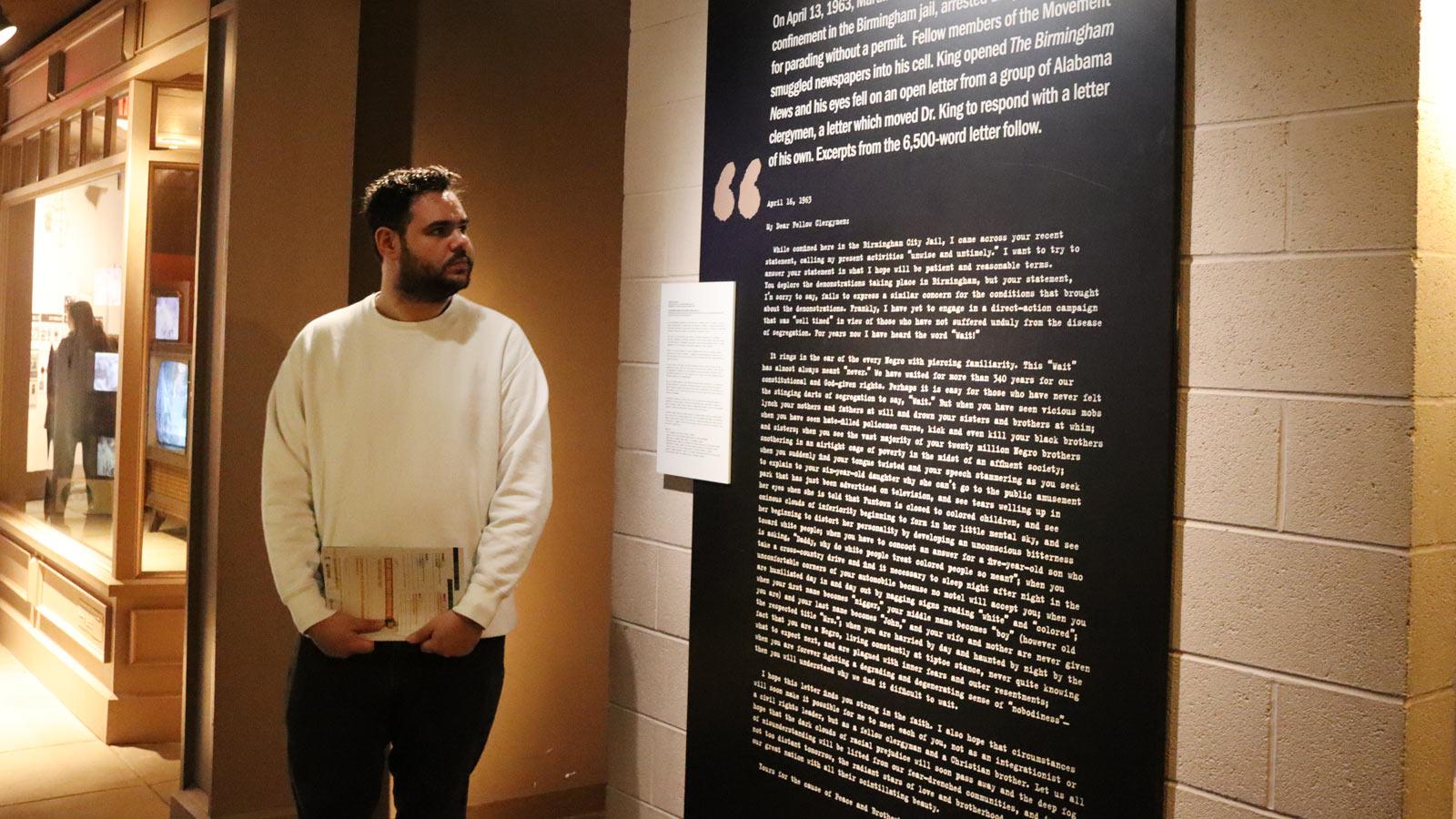 man reading the accompanying text of an installation.