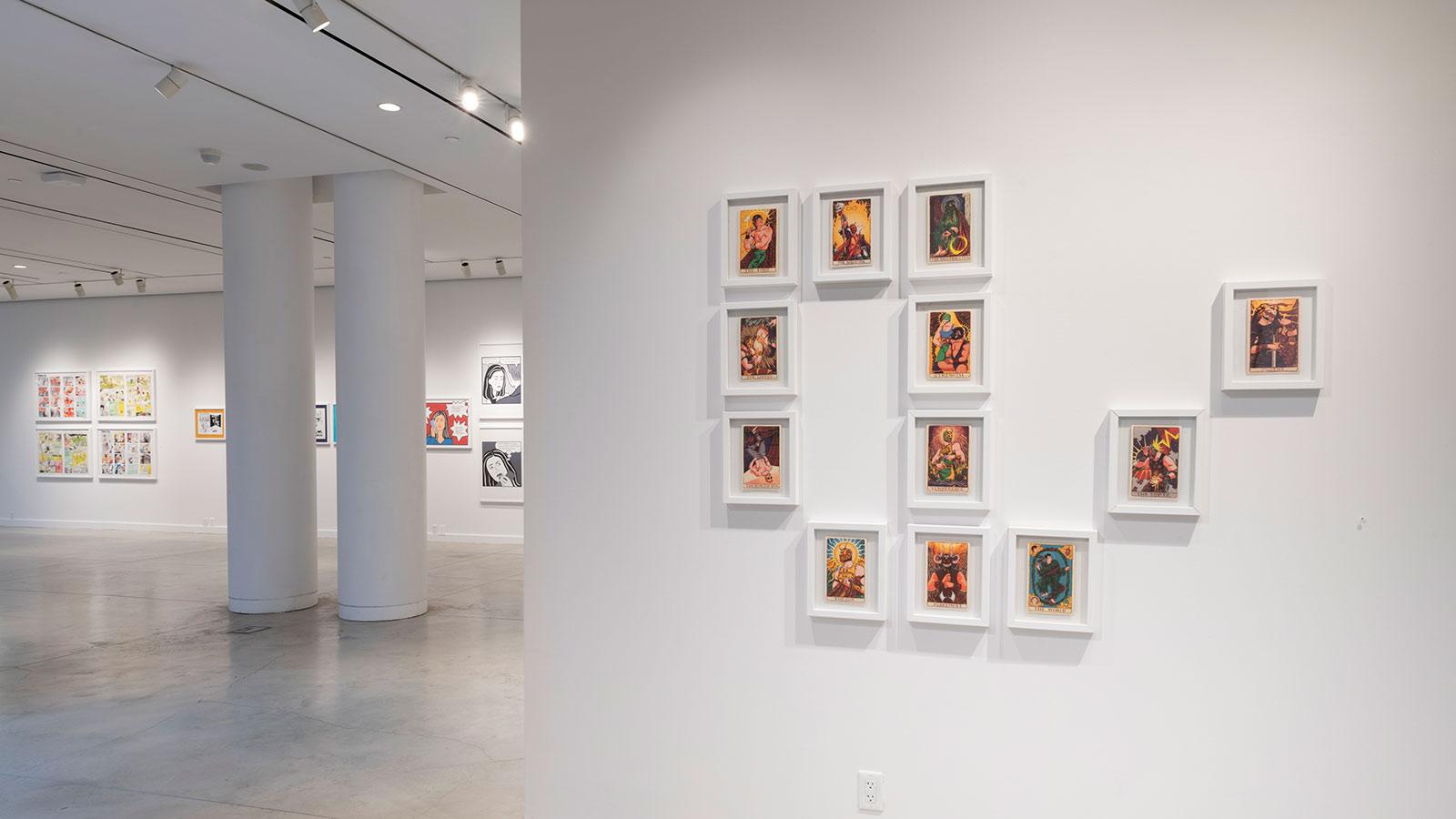 Artwork from various artists on display in the "Journey Illustrated" exhibition at the Pace University Art Gallery.