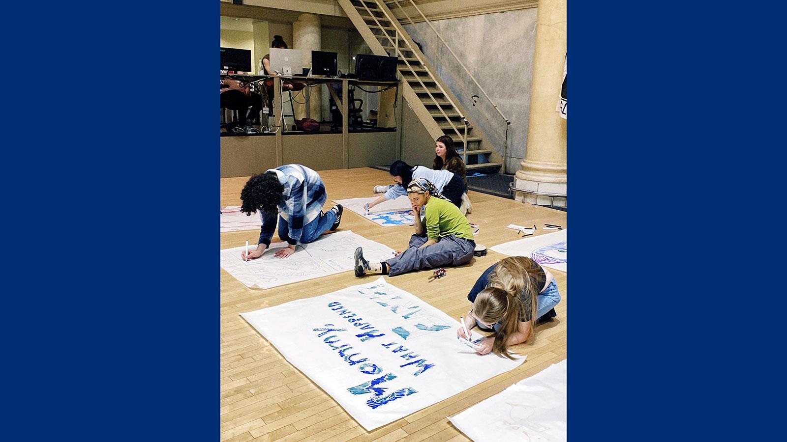 Pace University's Peace and Justice Studies and English students drawing signs and working with the Bread and Puppet Theater to express social justice through art.