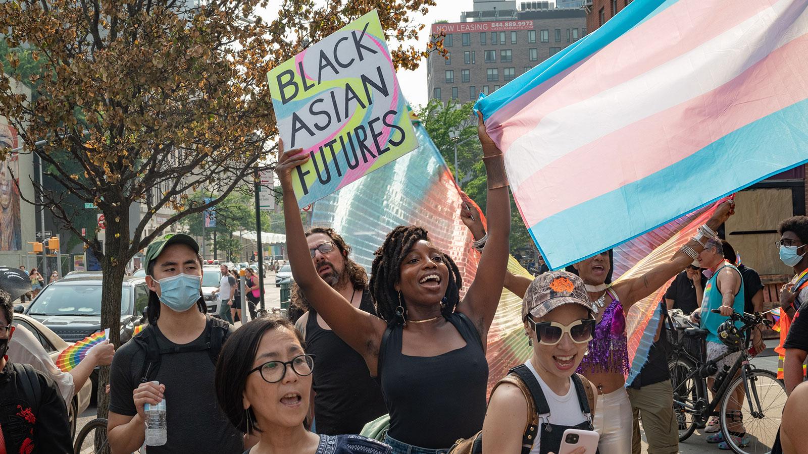 Photo by Stas Ginzburg of Blasian March Pride Rally in New York with people holding signs and flags