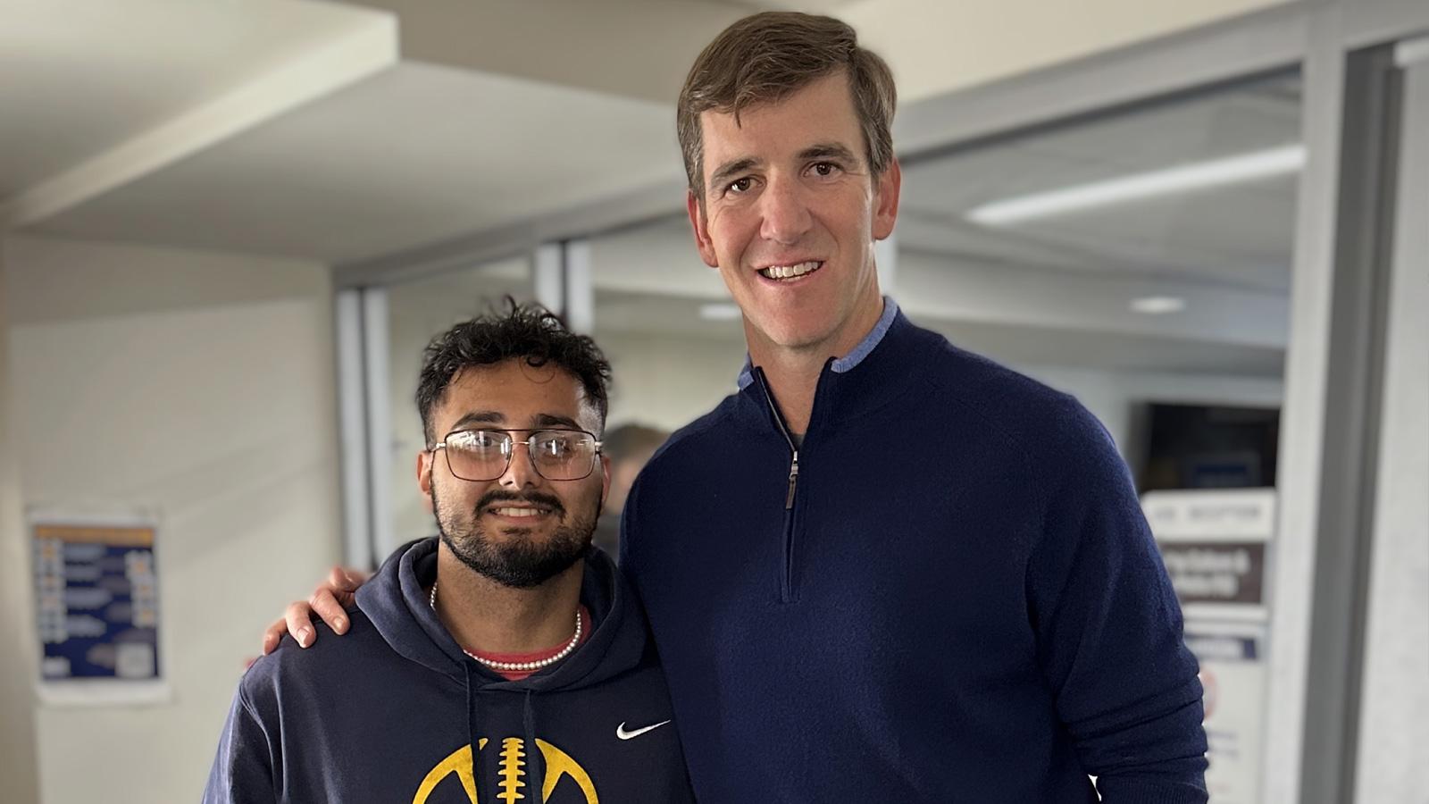 Eli Manning posing with Pace University student Rejos “Jose” Neopaney ’25