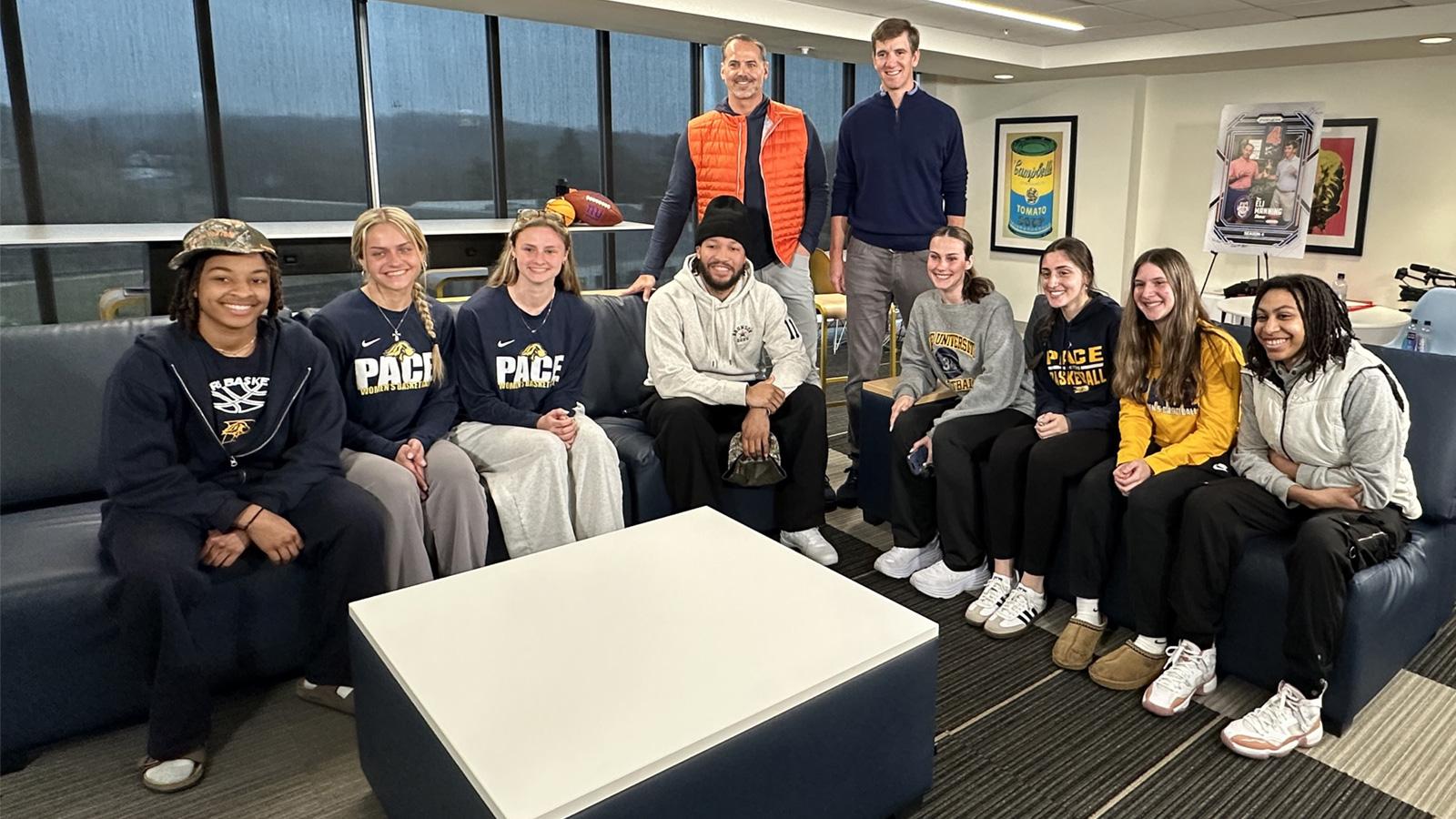 Pace women's basketball team posing with Jalen Brunson, Eli Manning, and Shaun O'Hara