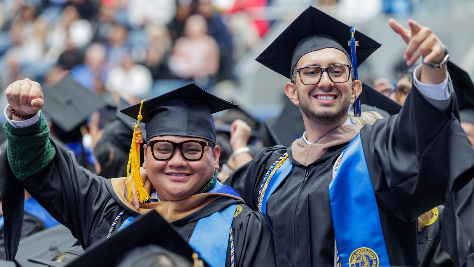 Graduates waving to the camera.