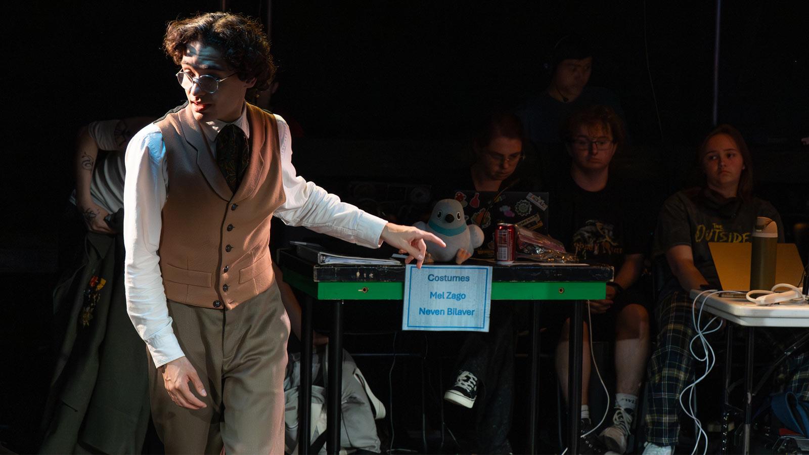 Actor rehearsing with crew behind him.