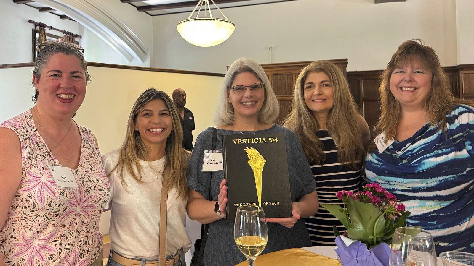 Group of Pace University alumni smiling at the camera at the College of White Plains 50th Anniversary.