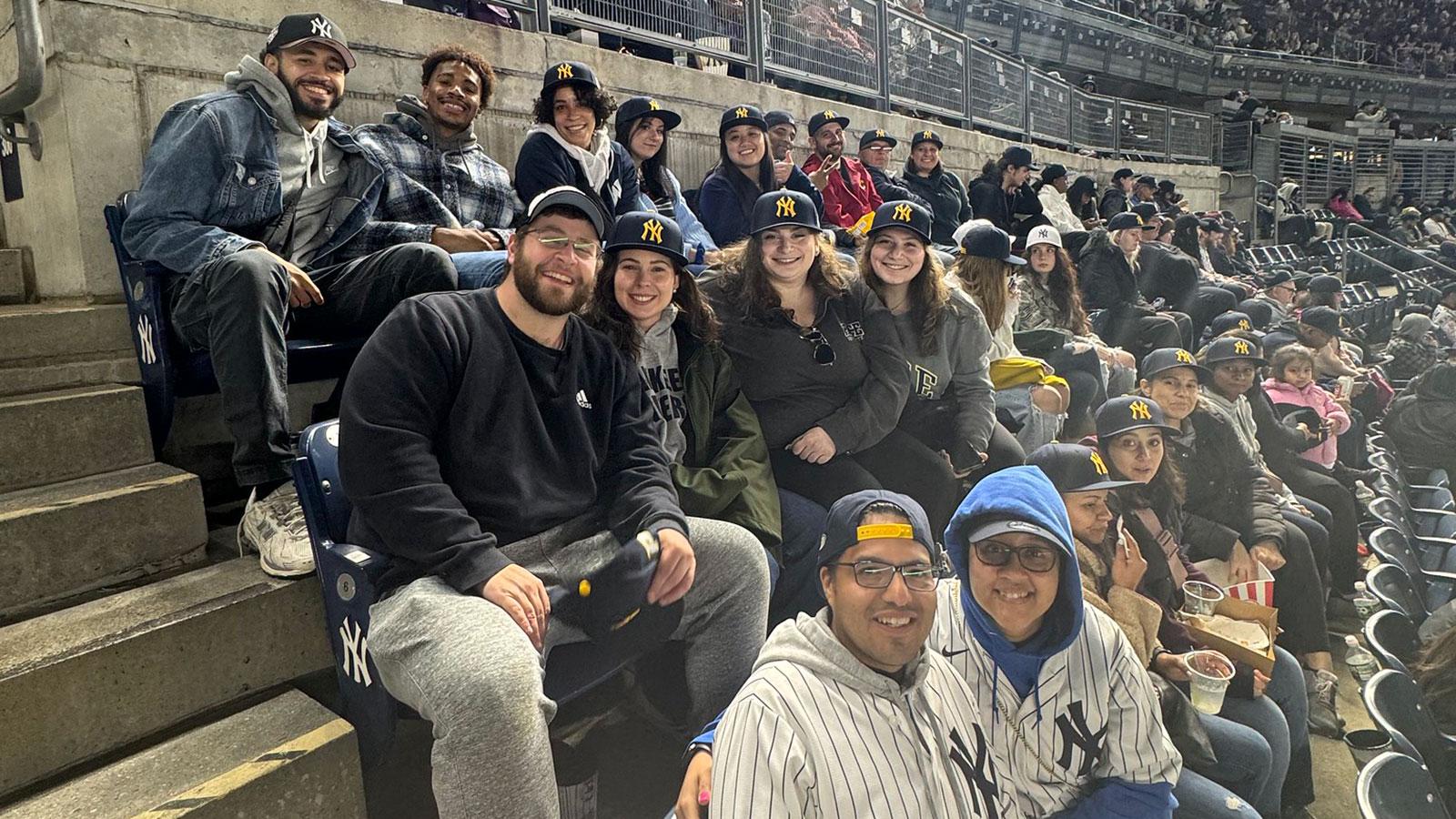 Group of Pace University alumni smiling at the camera at the Pace Day at Yankee Stadium event.