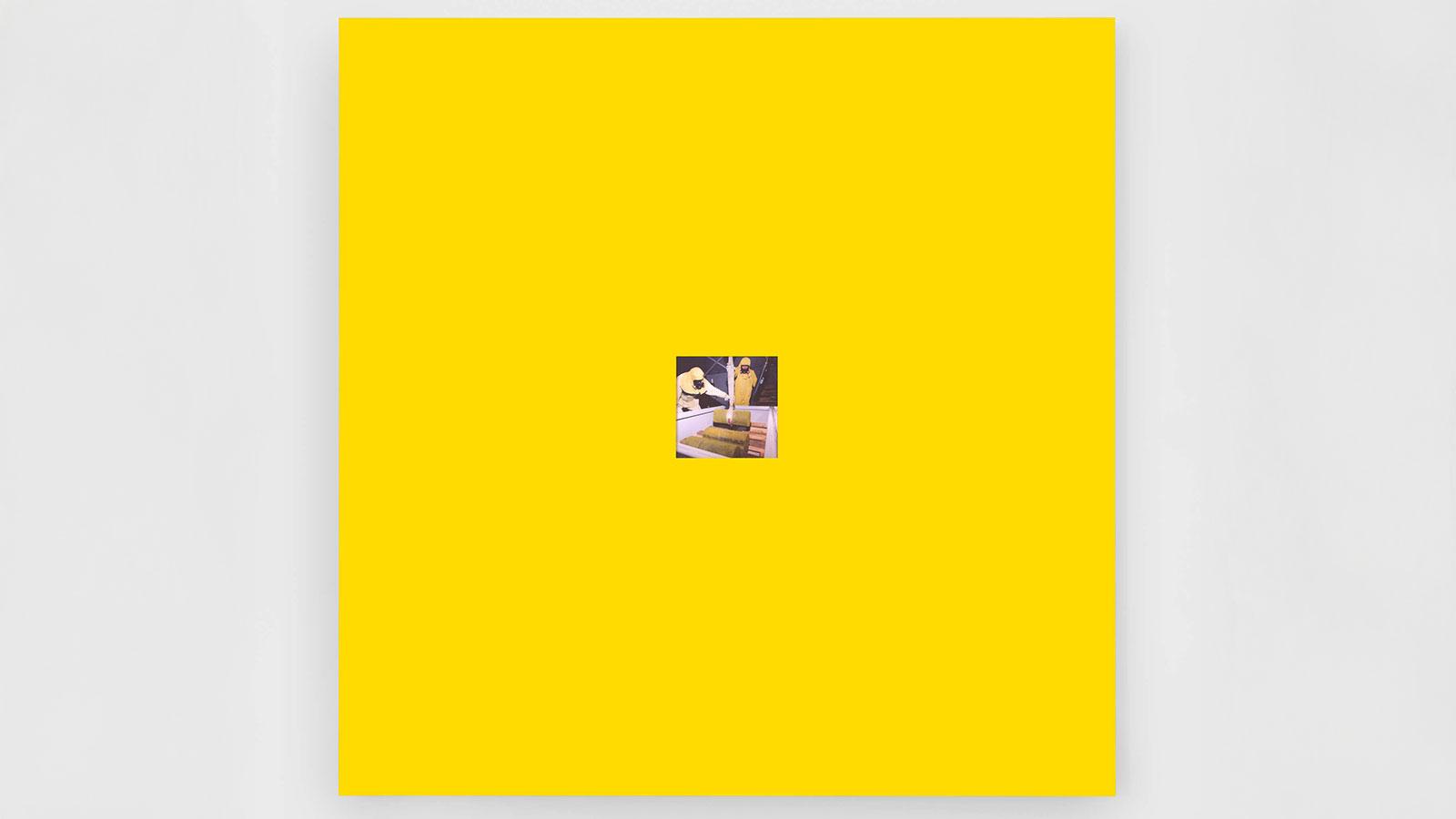 Large yellow canvas with a small photo by Michael Wang on view in the Pace University Art Gallery's Nuclear Injustice exhibition