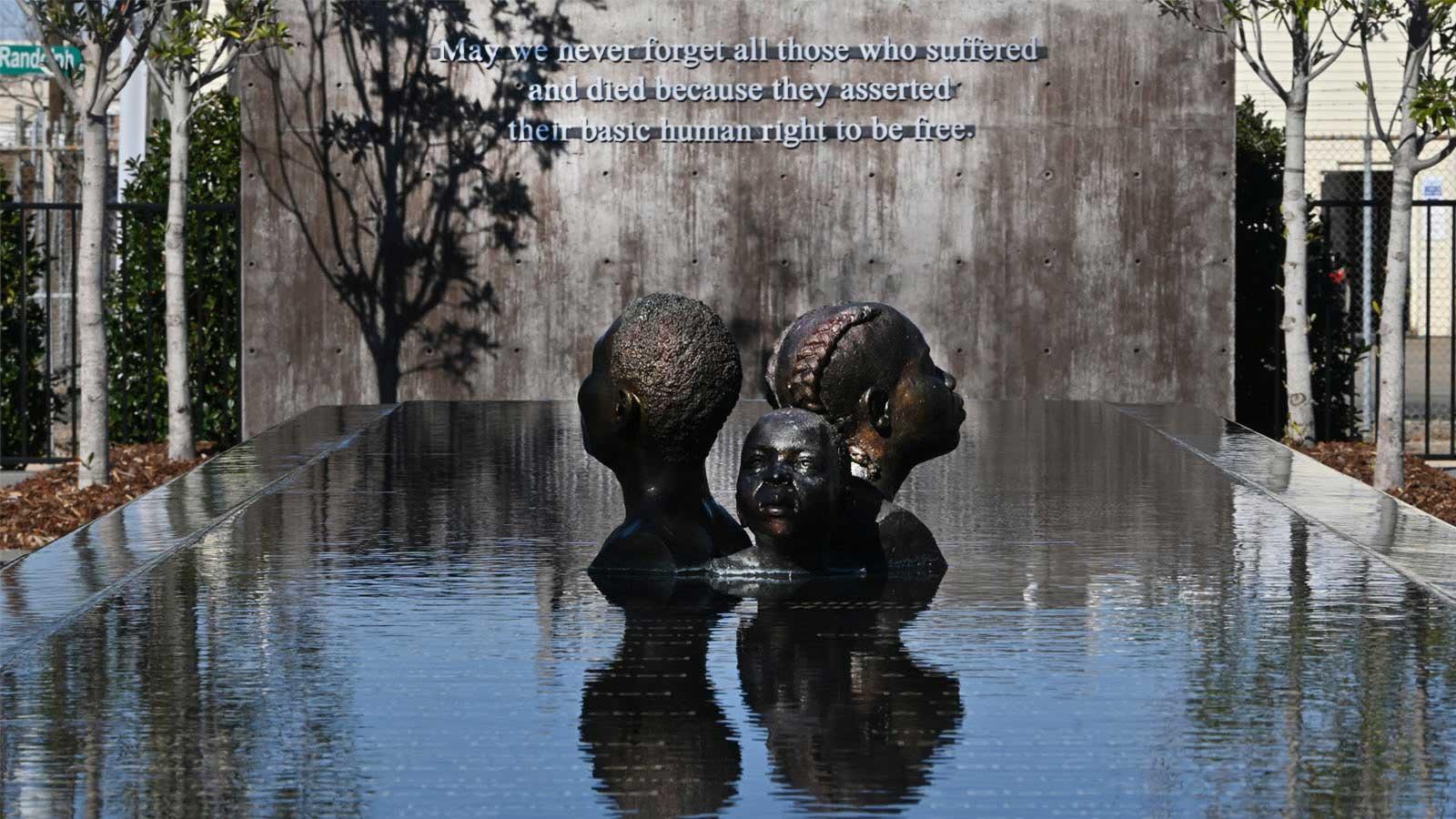 a granite statue of a Black family rising from water.