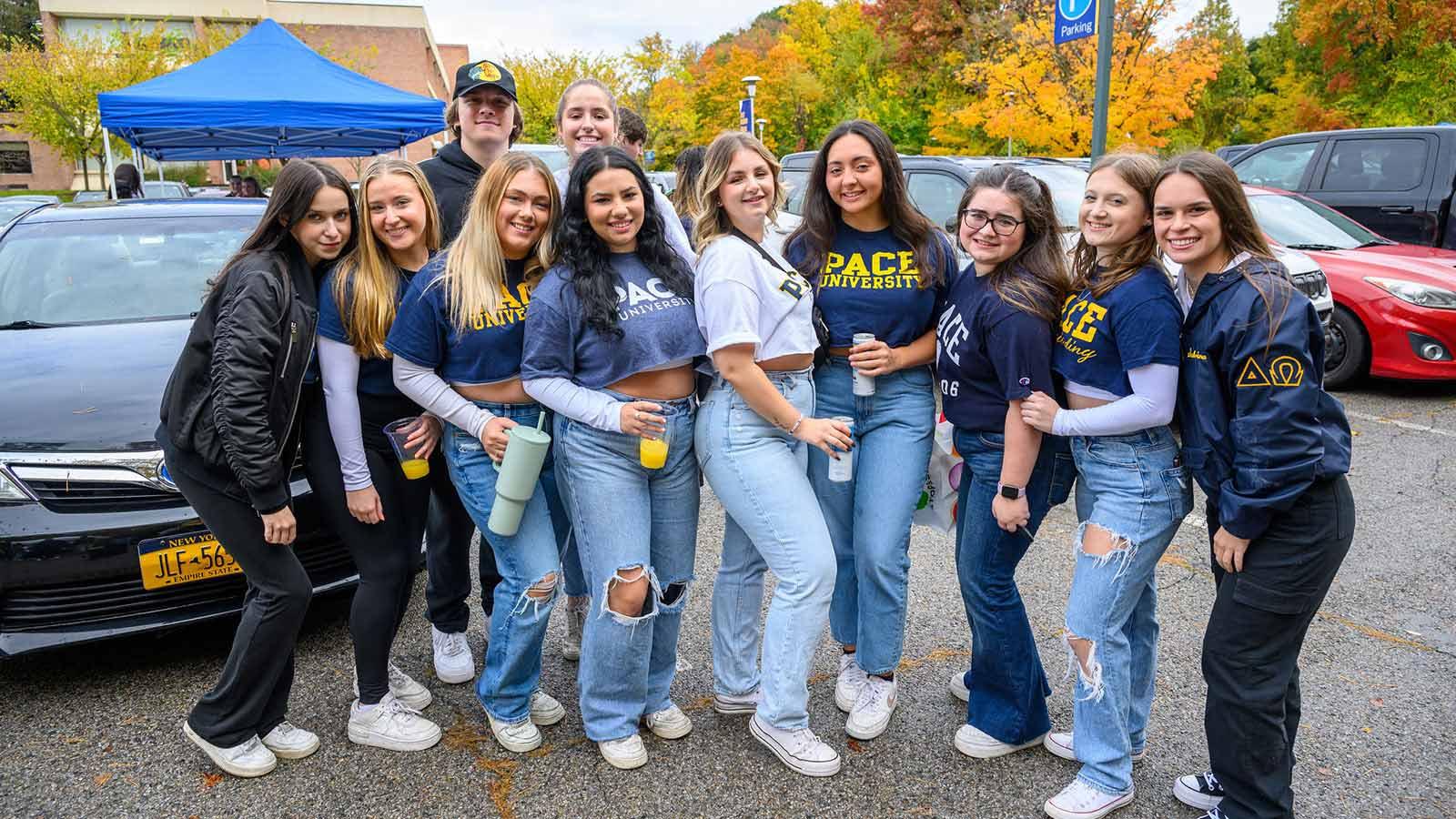 Group shot of Pace University students smiling at the camera at Homecoming.
