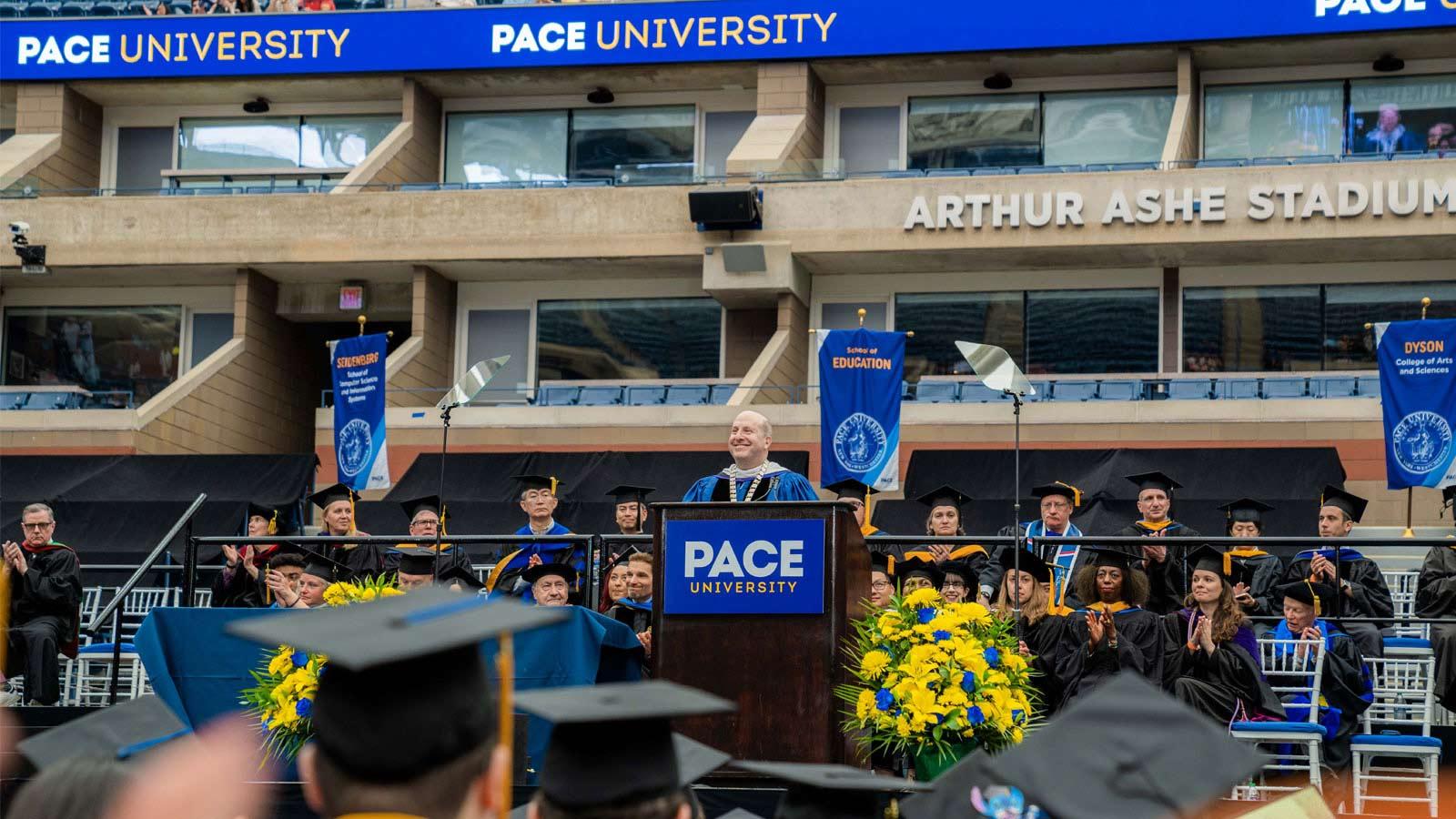 president krislov addressing the graduates on stage at commencement.