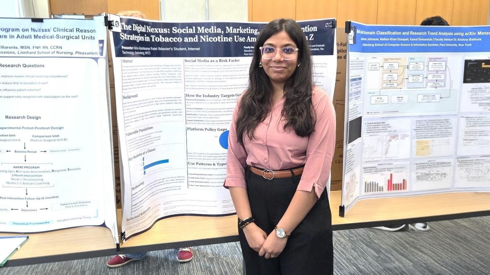 Hisha Patel posing in front of her poster presentation at the Annual Research Conference