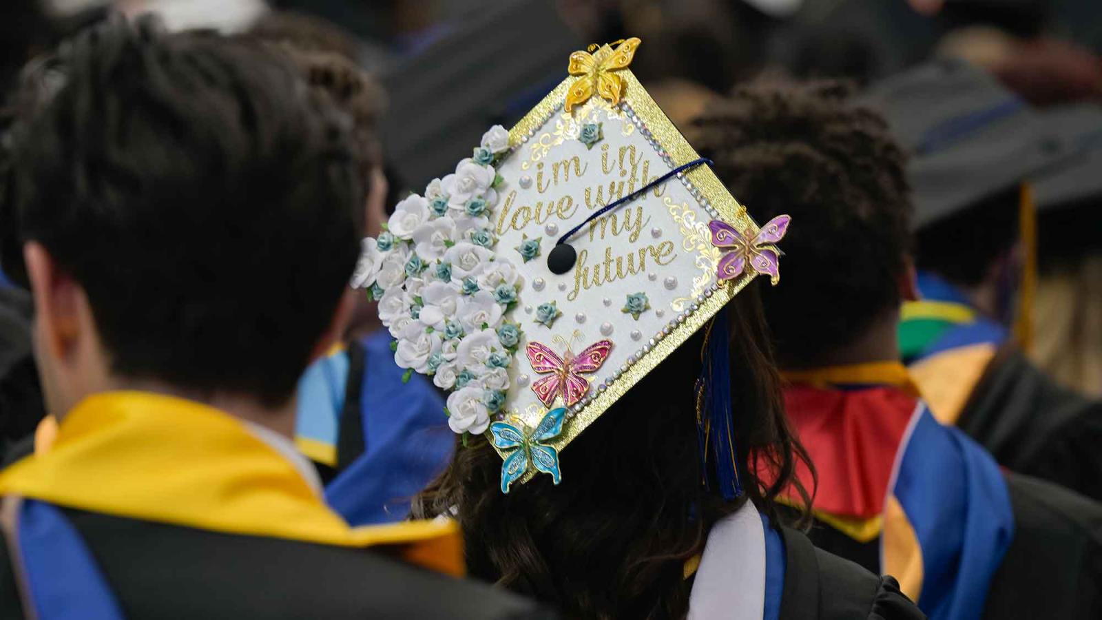 A decorate graduate's cap with florals and the words: I'm in love with my future