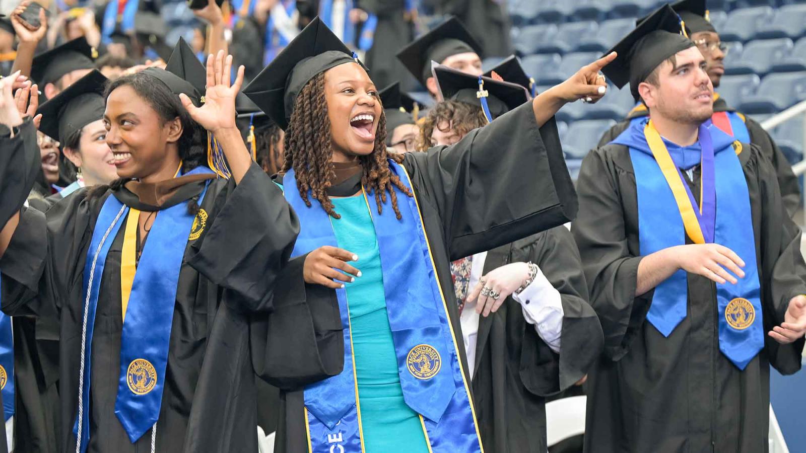A Pace University graduate points out across the crowd